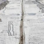 Route isolée au milieu d'un paysage enneigé et désolé