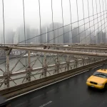 Taxi jaune sur le pont de Brooklyn par temps nuageux