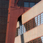 Structure métallique rouge et façade en briques