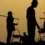 Silhouettes de travailleurs au crépuscule avec paniers