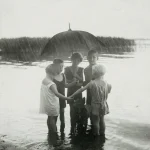 Enfants sous la pluie avec un chien et un parapluie