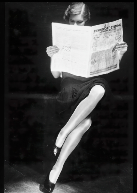 AKG1047702.webp Femme lisant un journal portant des talons hauts – Image 1