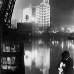 Vue nocturne d'une ville avec une femme pensant près de l'eau