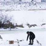 Pêcheur sur un lac gelé en hiver
