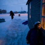 Enfants Jouant dans un Village Enneigé au Crépuscule
