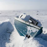 Bateau abandonné recouvert de neige dans un paysage arctique