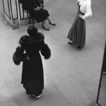 Séance de mode avec deux mannequins et une femme assise