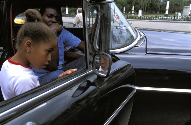 AKG1103826.webp Enfants et adulte dans une voiture noire vintage – Image 1
