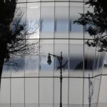 Réflexion d'un lampadaire sur une façade en verre