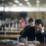 Homme lisant dans une bibliothèque