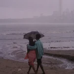 Couple marchant sur la plage sous la pluie