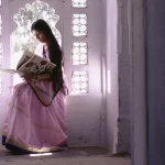 Femme en sari lisant dans un cadre traditionnel