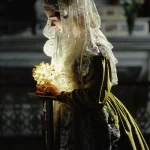 Femme en tenue traditionnelle avec voile tenant une bougie