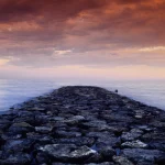 Un coucher de soleil sur une jetée rocheuse
