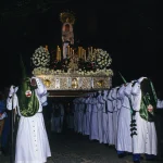 Procession religieuse de nuit avec statues et porteurs en vêtements traditionnels