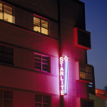 Façade d'hôtel avec enseignes au néon la nuit
