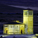 Église en pierre éclairée la nuit sur fond de campagne