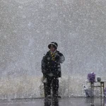 Personne debout sous la neige avec des sacs à côté