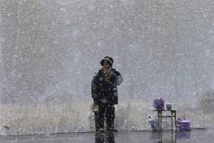 Personne debout sous la neige avec des sacs à côté