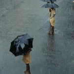 Deux personnes avec parapluies sur une route mouillée