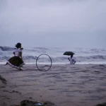 Enfant jouant sur la plage pendant une journée pluvieuse