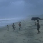 Enfants jouant sur une plage sous un ciel orageux