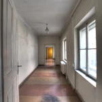 Corridor ancien et lumineux avec portes et fenêtres