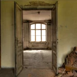 Vieille maison abandonnée avec portes ouvertes et fenêtre lumineuse