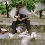 Homme âgé nourrissant des pigeons dans un parc
