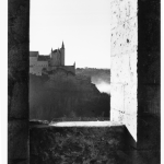 Vue sur un château médiéval depuis une fenêtre en pierre