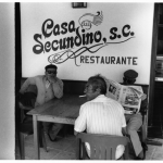 Trois hommes assis devant un restaurant Casa Secundino