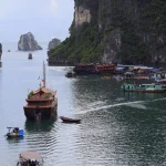 Bateaux traditionnels dans une baie entourée de falaises