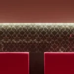 Bancs rouges avec un fond mural orné