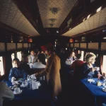 Wagon-restaurant avec des passagers et un serveur en uniforme