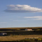 Paysage Rural avec Bâtiments Sous un Ciel Nuageux