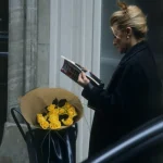 Femme lisant avec un bouquet de roses jaunes