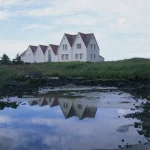 Maisons traditionnelles islandaises avec reflet dans l’eau