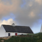 Maisons traditionnelles aux toits de chaume sous un ciel nuageux
