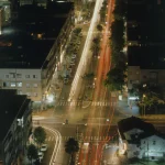 Vue nocturne d'une intersection urbaine animée.
