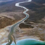 Vue aérienne d'un fleuve sinueux dans un paysage désertique