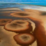Paysage désertique avec cercles de sel et montagnes en arrière-plan