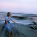 Cyclistes flous près de la mer au crépuscule