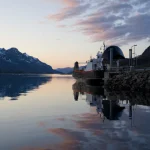 Ferry au crépuscule dans un paysage montagneux