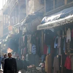 Rue commerçante animée avec des passants et des étalages de vêtements