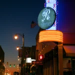 Panneaux lumineux de rue devant un club nocturne au crépuscule
