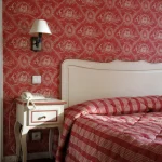 Décoration de chambre traditionnelle avec papier peint rouge et lit assorti