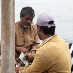 Transaction entre deux hommes en bord de mer