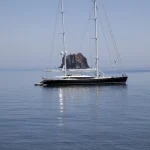 Yacht sur l'eau avec une île en arrière-plan