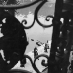 Vue d'une promenade au bord de la Seine depuis une grille en fer forgé