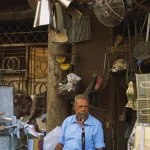 Homme âgé fumant un narguilé dans un marché